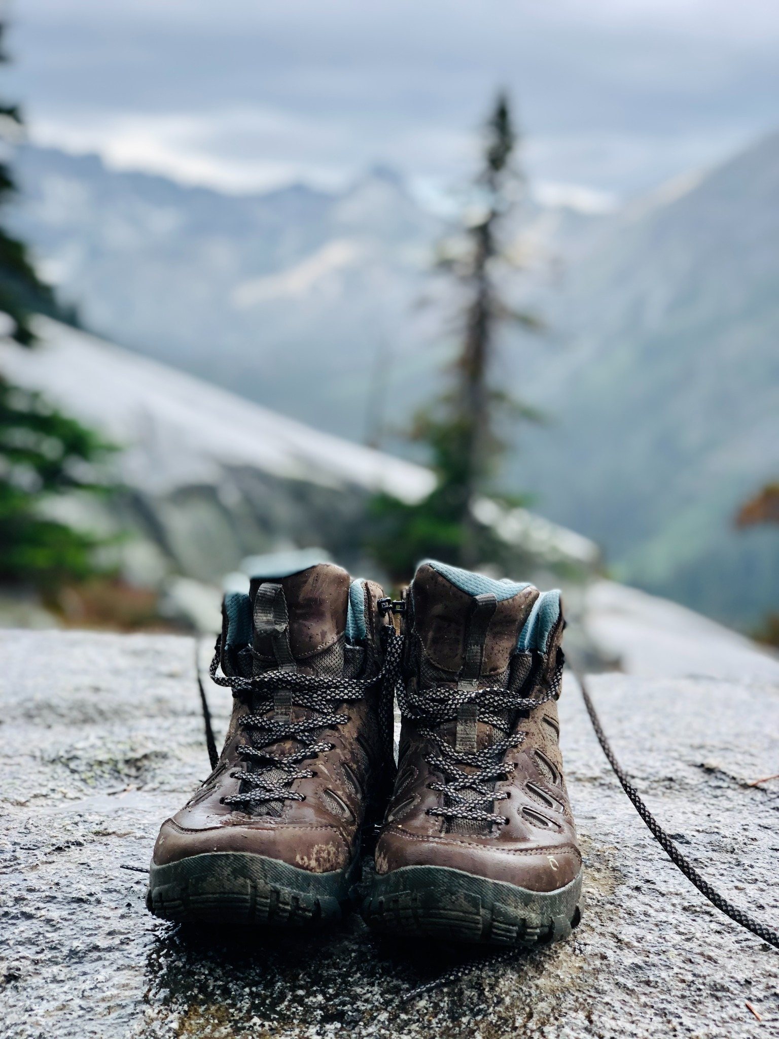 A pair of well-worn hiking boots in the mountains