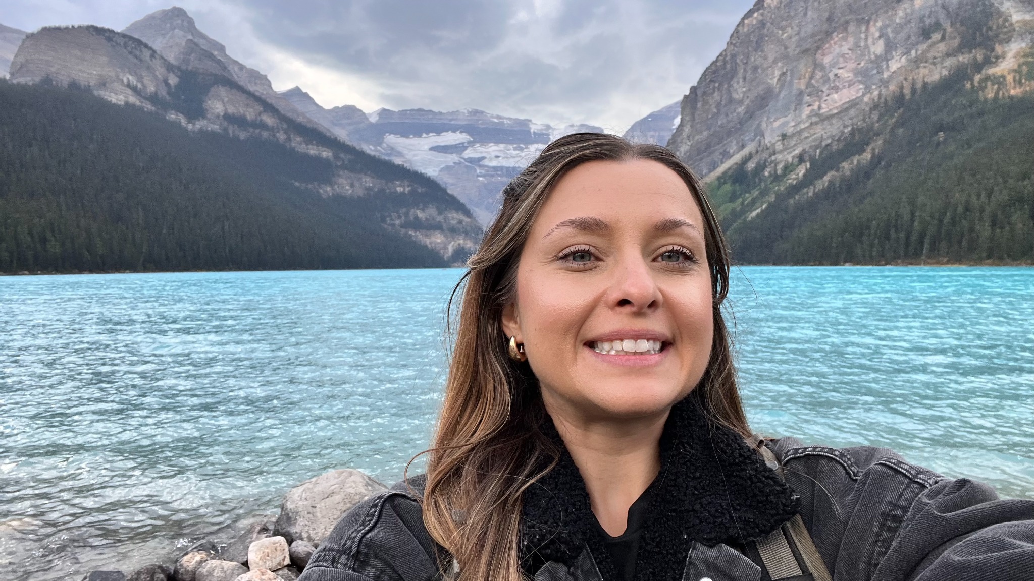 Jess beside the turquoise water and mountains at Lake Louise