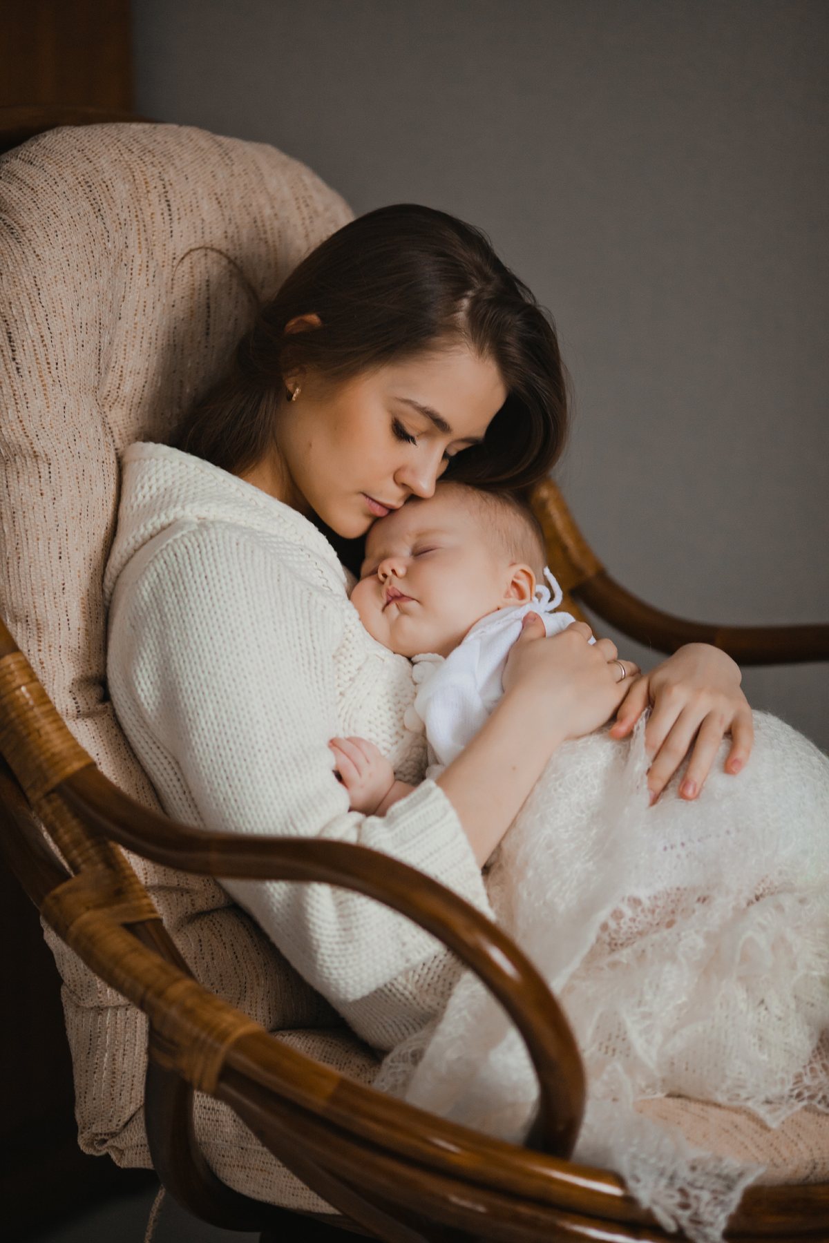 A mother gently holding and soothing her sleeping infant